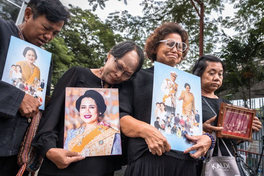 People hold portraits of Thailand's former Queen Sirikit as they gather in front of Chulalongkorn Hospital, where she passed away, in Bangkok on October 25.